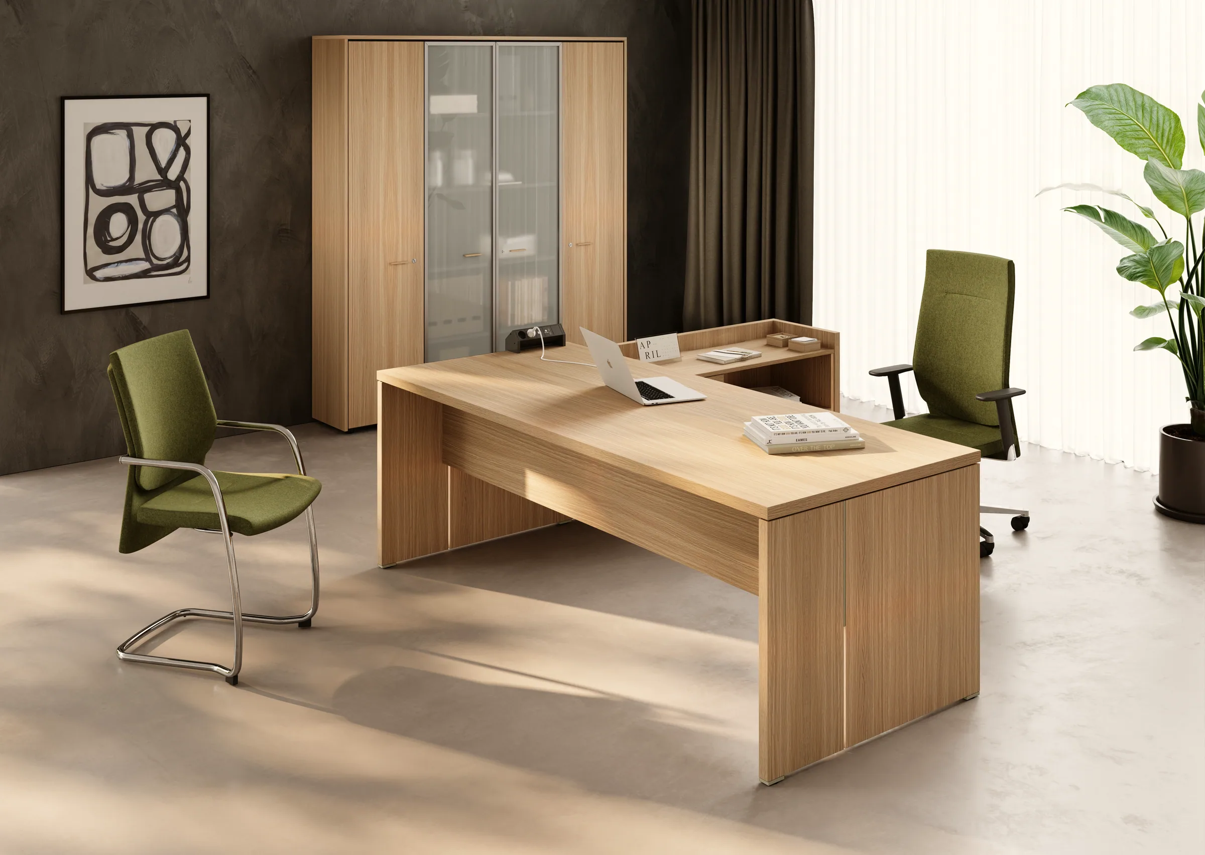 Ufficio direzionale con scrivania a L della linea Gamma in rovere chiaro: piano principale con fianchi a pannello e allungo laterale rialzato con presa elettrica integrata.